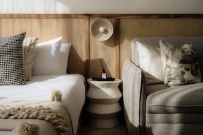 A bedroom with a bed, bedside tables, and a chair.