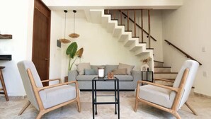 A living room with two armchairs, a sofa, a coffee table, and a staircase. - Casa Kaatal Sunny Penthouse Pool Beach Club Access (Tulum)
