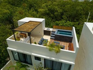Una terraza moderna en la azotea con piscina, mobiliario exterior y cubierta de madera.