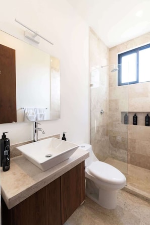 A modern bathroom with a large sink, a toilet, and a glass-enclosed shower. - Casa Kaatal Sunny Penthouse Pool Beach Club Access (Tulum)