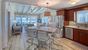 A modern kitchen with a central island, stainless steel appliances, and a view to the outside.