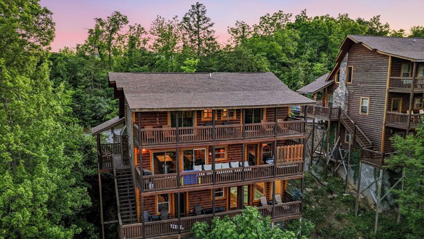 A multi-story log cabin with balconies and outdoor seating, surrounded by dense forest. - Game Loft*Private Pool*1 mile to Pigeon Forge Parkway (PIGEON FORGE)