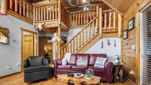 A wooden interior with a staircase, a leather sofa, and a rustic coffee table. - Friends/Couples*Game room w/ poker table*Close to everything (PIGEON FORGE)