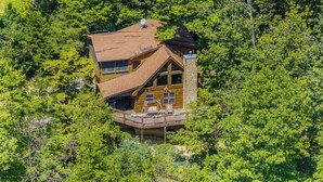A cabin with a large deck, surrounded by dense forest. - Friends/Couples*Game room w/ poker table*Close to everything (PIGEON FORGE)