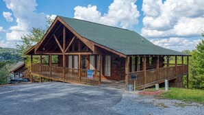 A wooden lodge with a covered porch and a steep driveway. - Easy Access Roads*In Pigeon Forge*Jacuzzi and hot tub (PIGEON FORGE)