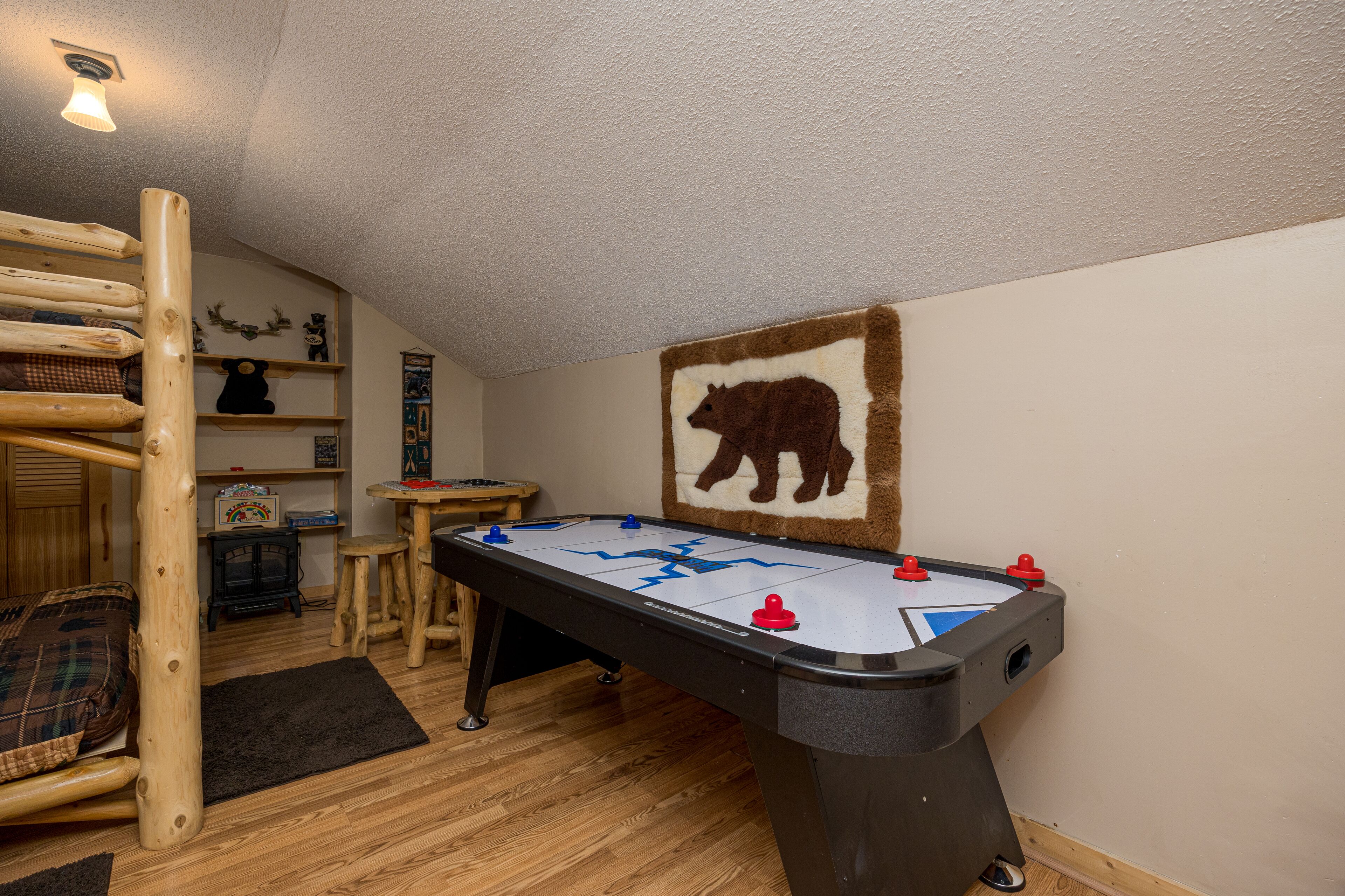 A cozy room with a foosball table, a wooden ladder, and a bear-themed wall decoration.