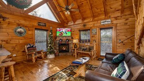 Un interior acogedor de cabaña de madera con chimenea, muebles de madera y un árbol de Navidad.
