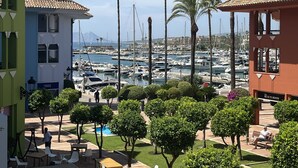 A marina with boats, palm trees, and a building with a sign reading "The Beauty Room".