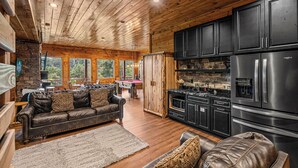 A spacious living room with a leather sofa, a dining area with a pool table, and a kitchen with modern appliances. - Wears Valley*Mtn Views*Tons of Great Amenities*Gated Resort (PIGEON FORGE)