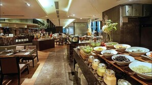 Un espace buffet proposant une variété de plats et différents types de tables et de chaises.
