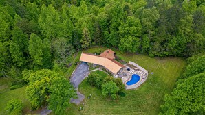 An aerial view of a house with a swimming pool, surrounded by dense green trees. - House in Gatlinburg*Private Outdoor Pool*Fire Pit*Pool Table (GATLINBURG)