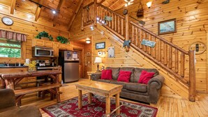 A wooden cabin interior with a kitchen, dining area, and living room. - Gatlinburg*Hot Tub*Wifi/Cable*Resort Pool (Seasonal) (GATLINBURG)