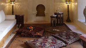 A room with a patterned ceiling, a chandelier, a fireplace, and traditional furnishings. - El Morocco Hotel (Marrakech)