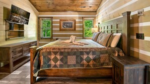 Ein Schlafzimmer mit einem großen Bett, einem hölzernen Kopfstück und einem Bild an der Wand.