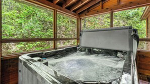 A hot tub with a wooden ceiling and large windows overlooking a forested area. - Luxury Log Home*Views*Close to Pigeon Forge*WiFi*Hot Tub (PIGEON FORGE)