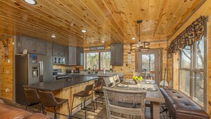 A wooden cabin interior with a kitchen, dining area, and seating. - Cabin with Indoor Pool and Lots of Entertainment (PIGEON FORGE)