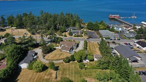 An aerial view of a residential area with houses, a dock, and a body of water.