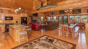 A log cabin interior with a kitchen, living area, and dining space. - Luxury Log Lodge with Mountain Views (SEVIERVILLE)