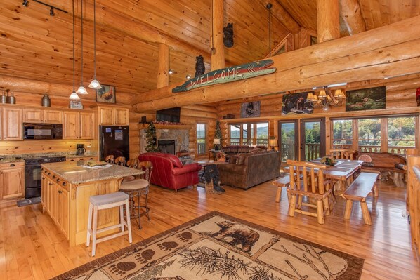 A log cabin interior with a kitchen, living area, and dining space. - Luxury Log Lodge with Mountain Views (SEVIERVILLE)