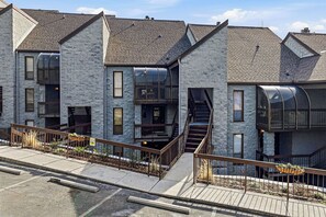 A modern building with a stone facade, large windows, and a staircase leading to an upper level. - A Mountain Top Retreat (GATLINBURG)