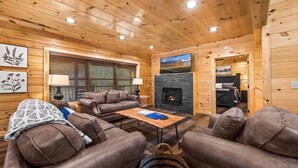 Un intérieur de chalet chaleureux avec une cheminée, des murs en bois et un coin salon confortable.