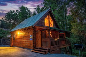 A wooden cabin with a large window, a porch, and a mailbox. - Gatlinburg Celebration Destination (GATLINBURG)