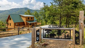 A wooden cabin with a green roof, a wooden deck, and a sign reading "JS Hideaway". - Retreat To The Mountain Lair (SEVIERVILLE)