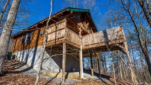 A wooden cabin with a balcony, surrounded by trees. - The Perfect Couple’s Retreat (PIGEON FORGE)