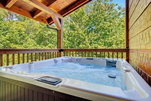 A hot tub under a wooden pergola with a view of green trees. - Crown Your Vacation With Fun Nearby (SEVIERVILLE)