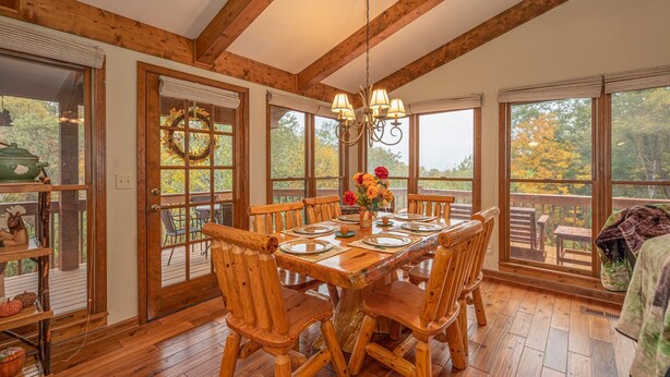 A wooden dining room with a large table set for six, surrounded by wooden chairs. - Pigeon Forge*Easy Access Rds*WiFi*Hot Tub (SEVIERVILLE)