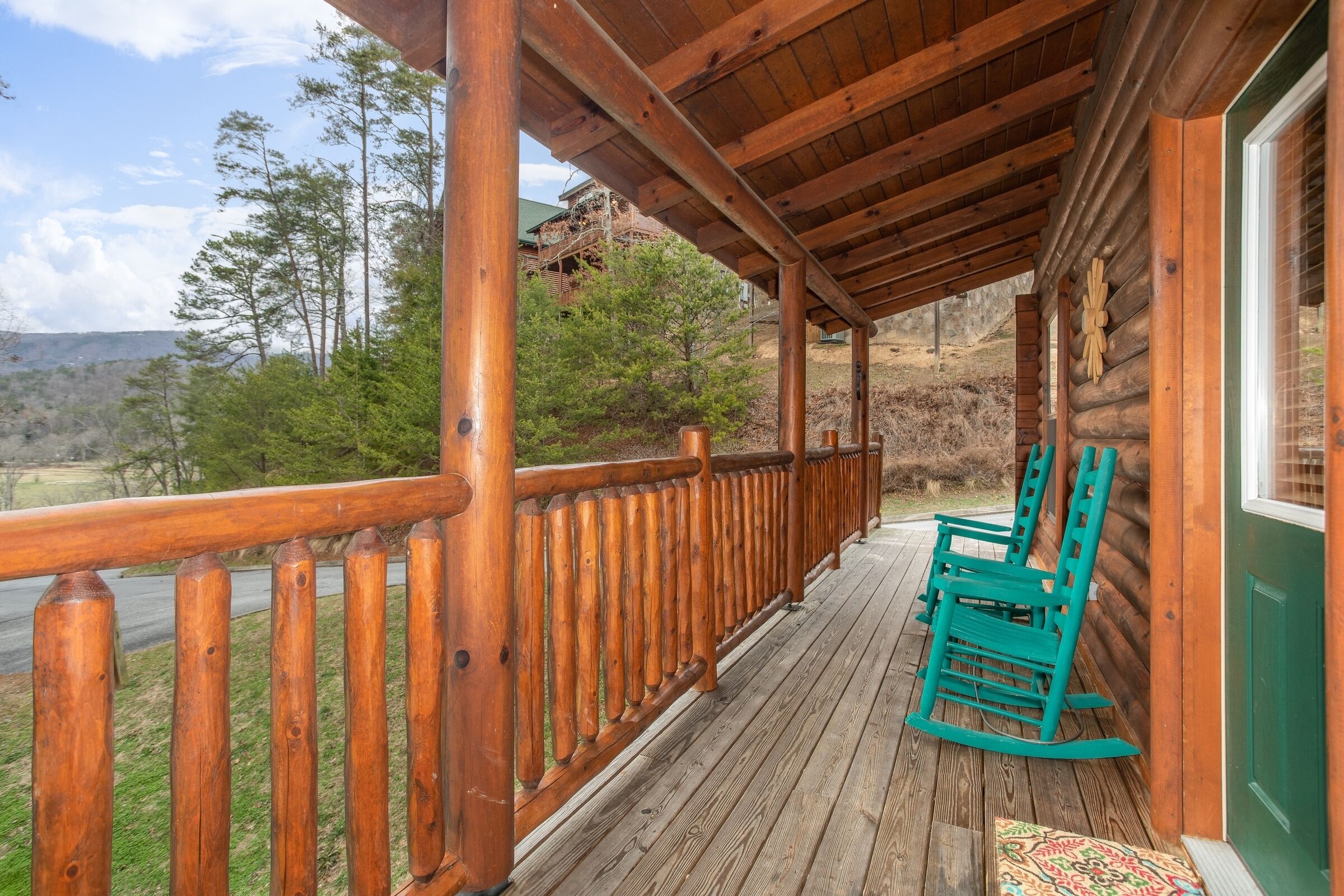 A wooden porch with a view of a mountainous landscape.
