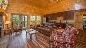 L’intérieur d’un chalet en bois comprend un salon, une cuisine et un coin repas.