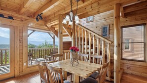 A wooden interior with a dining table, chairs, a chandelier, and a staircase. - Feel Like A Millionaire Relaxing In These Views (SEVIERVILLE)