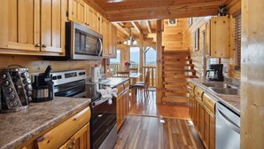 A wooden cabin kitchen with a microwave, stove, and sink. - Feel Like A Millionaire Relaxing In These Views (SEVIERVILLE)