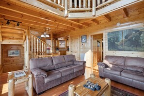 Een houten cabin met twee banken, een eettafel en een trap.