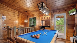 A wooden cabin with a pool table, a billiards rack, and a television mounted on the wall. - Come getaway to a cabin in the Moonlit Pines (SEVIERVILLE)