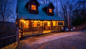 A rustic cabin with a metal roof, wooden exterior, and a porch with a railing. - Making Memories You'll Never Forget (SEVIERVILLE)