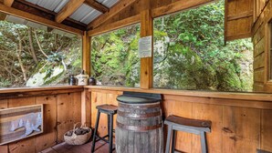 Une cabane en bois avec de grandes fenêtres, un tonneau en bois et une illustration d’ours sur le mur.