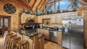 Una cocina moderna con armarios de madera, un refrigerador de acero inoxidable y una isla grande con taburetes de bar.