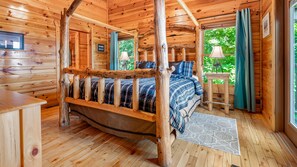 Cozy bedroom with a wooden bed, wooden nightstand, and a lofted sleeping area above.