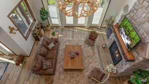 A spacious living room with a large sofa, coffee table, and fireplace.