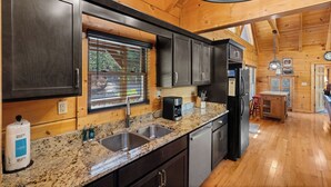 Una cocina con encimeras de granito, electrodomésticos de acero inoxidable y armarios de madera.