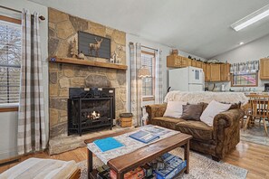 Ein gemütliches Wohnzimmer mit Kamin, einer Couch und einem Couchtisch.