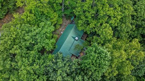 An aerial view of a house surrounded by dense green trees. - Mountain Views-Hot Tub-Fireplace-Close to Dollywood (SEVIERVILLE)