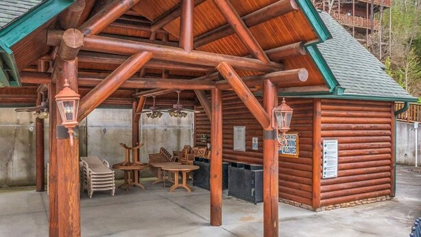Uma cabana de toras com um alpendre coberto, mobiliário de madeira e um aviso indicando que mergulho é permitido.