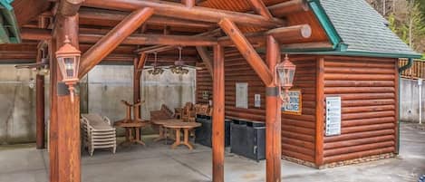 Een blokhut met een overdekt terras, houten meubilair en een bordje waarop staat dat duiken is toegestaan.