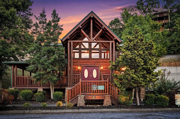 A log cabin-style building with a porch, a sign indicating it is a private property, and a view of the surrounding trees. - Surround Yourself In Fun Both Indoors And Out (PIGEON FORGE)