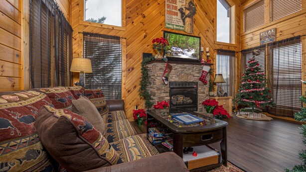 Ein gemütliches Blockhaus-Interieur mit Kamin, Weihnachtstann und einer bequemen Sitzecke.
