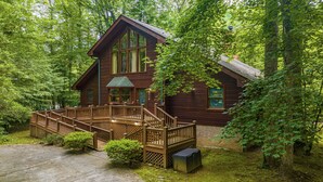 A wooden cabin with a deck, surrounded by dense forest. - Accessible (Not ADA)*Gatlinburg*Relaxing (SEVIERVILLE)