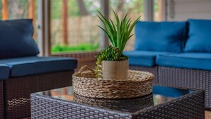 A wicker sofa with a woven basket and a potted plant on a glass table. - Private Jetted POOL, Firepit & BBQ in a Stunning House By Airport (San Antonio)